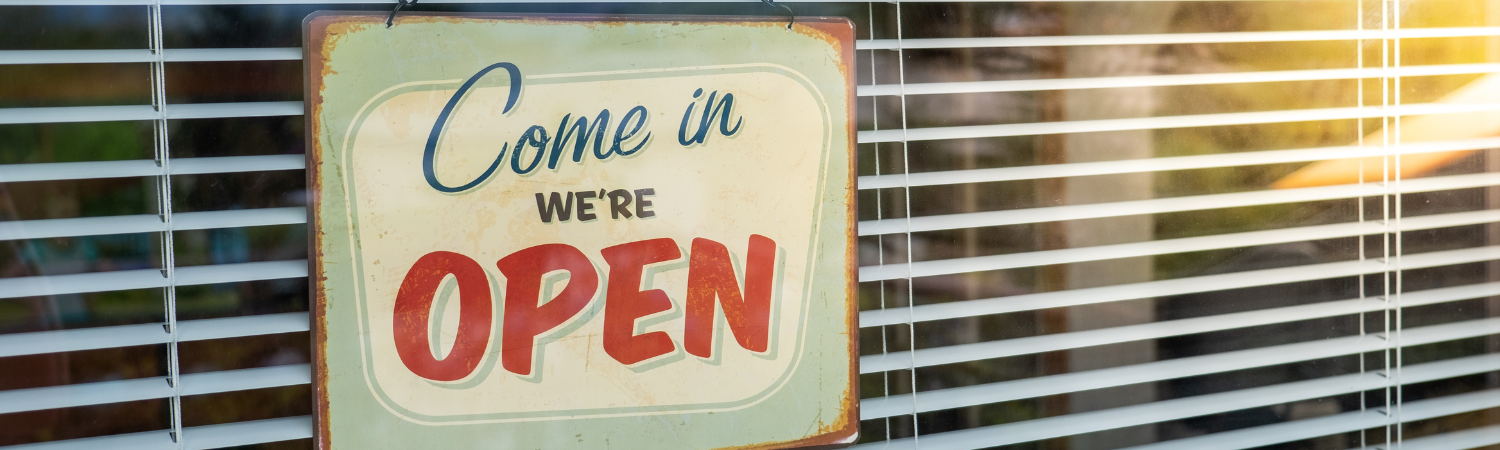 Blinds with sign that says Come In We're Open