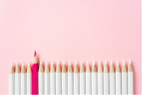 White pencils in a line with one pink pencil sticking out.