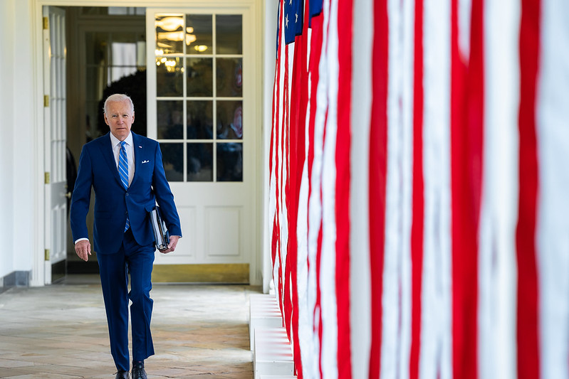Photo of President Biden walking along White House Colonnade